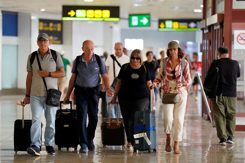 Petugas kepolisian nasional Spanyol memantau kedatangan para pelancong dari Italia di Bandara Madrid-Barajas, Madrid, Spanyol, pada 8 Agustus 2026, setelah pemerintah Spanyol mengumumkan akan memberlakukan pemeriksaan perbatasan untuk penerbangan dan kapal dari Italia&mdash;mulai tengah malam hari Sabtu hingga 7 September&mdash;di tengah sengketa mengenai migrasi ilegal. (Spanish Police/Handout via REUTERS)