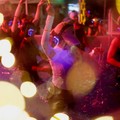 Orang-orang yang mengenakan headphone nirkabel menari di dalam kolam untuk menyejukkan diri—terlihat melalui sebuah bola yang menyala—dalam acara "Silent Evening Pool Party" di Alun-alun Gwanghwamun di tengah gelombang panas di Seoul, Korea Selat
