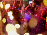 Orang-orang yang mengenakan headphone nirkabel menari di dalam kolam untuk menyejukkan diri—terlihat melalui sebuah bola yang menyala—dalam acara "Silent Evening Pool Party" di Alun-alun Gwanghwamun di tengah gelombang panas di Seoul, Korea Selat