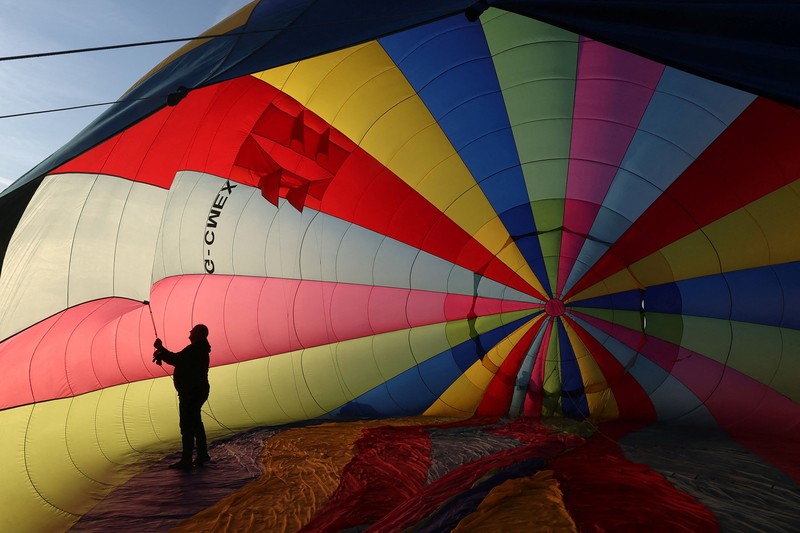 Warga menyaksikan balon udara terbang saat peluncuran massal di acara tahunan Bristol International Balloon Fiesta di Bristol, Inggris, pada 8 Agustus 2026. (REUTERS/Toby Melville)