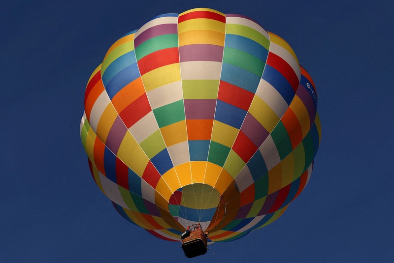 Warga menyaksikan balon udara terbang saat peluncuran massal di acara tahunan Bristol International Balloon Fiesta di Bristol, Inggris, pada 8 Agustus 2026. (REUTERS/Toby Melville)