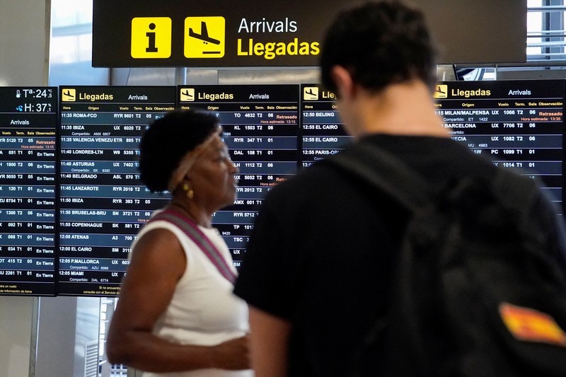 Petugas kepolisian nasional Spanyol memantau kedatangan para pelancong dari Italia di Bandara Madrid-Barajas, Madrid, Spanyol, pada 8 Agustus 2026, setelah pemerintah Spanyol mengumumkan akan memberlakukan pemeriksaan perbatasan untuk penerbangan dan kapal dari Italia&mdash;mulai tengah malam hari Sabtu hingga 7 September&mdash;di tengah sengketa mengenai migrasi ilegal. (Spanish Police/Handout via REUTERS)