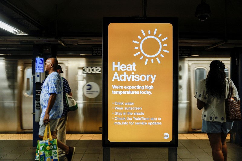 Seorang pejalan kaki menggunakan kipas tangan saat gelombang panas melanda New York City, AS, pada 7 Agustus 2026. (REUTERS/Jeenah Moon)