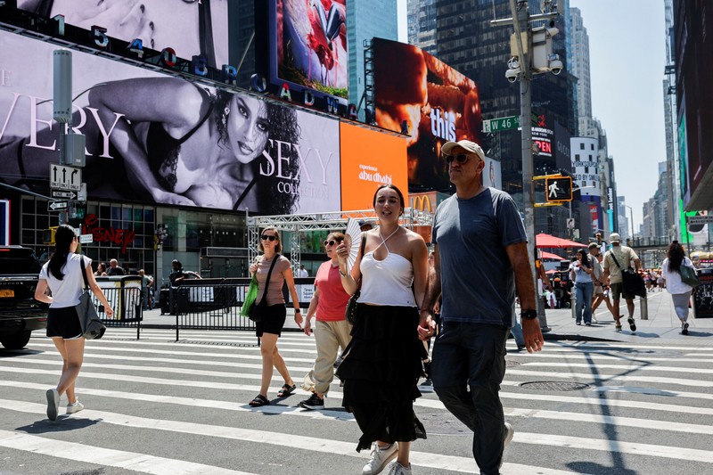 Seorang pejalan kaki menggunakan kipas tangan saat gelombang panas melanda New York City, AS, pada 7 Agustus 2026. (REUTERS/Jeenah Moon)