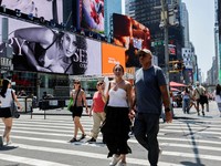 Seorang pejalan kaki menggunakan kipas tangan saat gelombang panas melanda New York City, AS, pada 7 Agustus 2026. (REUTERS/Jeenah Moon)