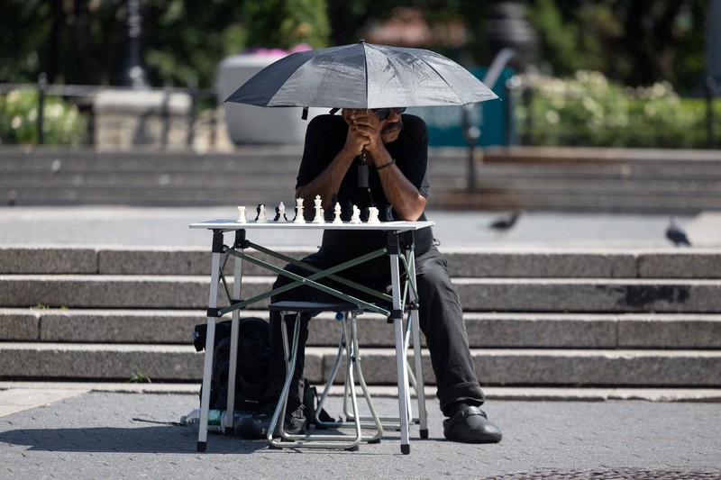 Seorang pejalan kaki menggunakan kipas tangan saat gelombang panas melanda New York City, AS, pada 7 Agustus 2026. (REUTERS/Jeenah Moon)
