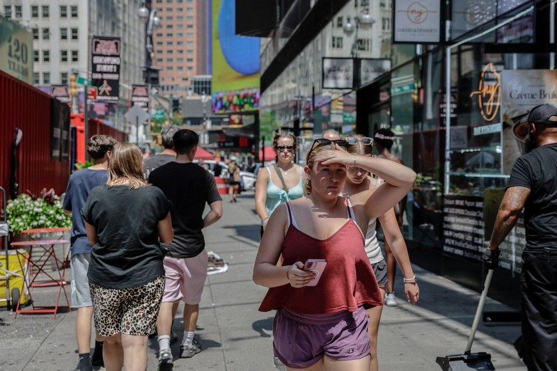 Seorang pejalan kaki menggunakan kipas tangan saat gelombang panas melanda New York City, AS, pada 7 Agustus 2026. (REUTERS/Jeenah Moon)