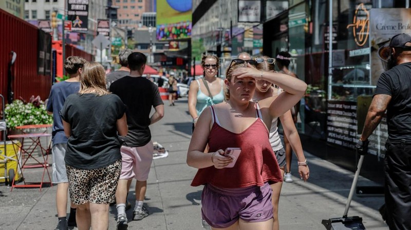 Seorang wanita melindungi wajahnya dari sinar matahari dengan tangannya saat gelombang panas melanda New York City, AS, pada 6 Agustus 2026.