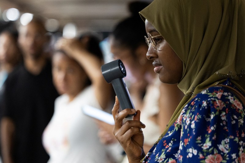 Seorang pejalan kaki menggunakan kipas tangan saat gelombang panas melanda New York City, AS, pada 7 Agustus 2026. (REUTERS/Jeenah Moon)