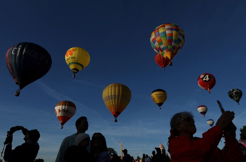 Warga menyaksikan balon udara terbang saat peluncuran massal di acara tahunan Bristol International Balloon Fiesta di Bristol, Inggris, pada 8 Agustus 2026. (REUTERS/Toby Melville)
