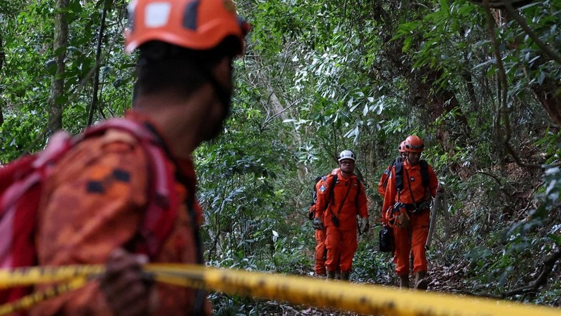 Petugas pemadam kebakaran berjalan melintasi kawasan hutan dalam operasi evakuasi setelah kecelakaan helikopter di dekat titik pandang Vista Chinesa, Rio de Janeiro, Brasil, 8 Agustus 2026.