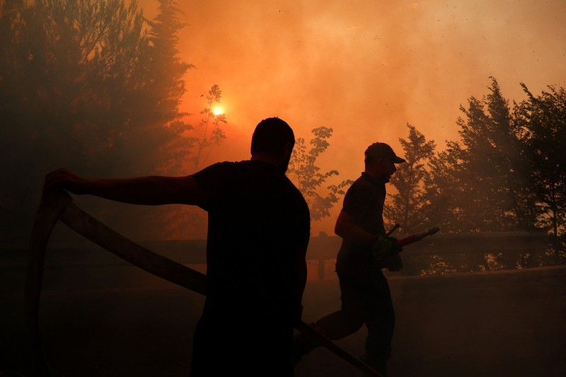 Warga setempat menyaksikan asap membubung dari kebakaran hutan yang melanda Kruja, Albania, pada 9 Agustus 2026. (REUTERS/Florion Goga)
