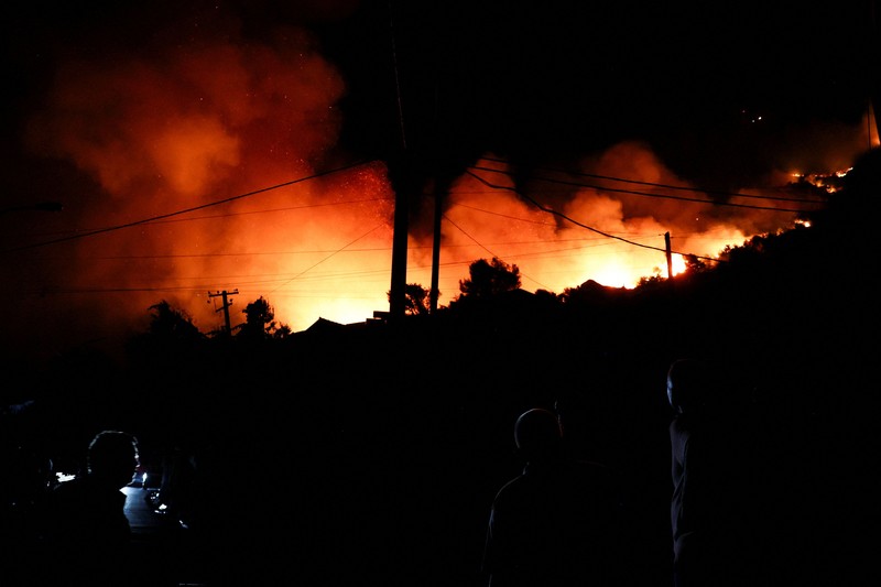 Warga setempat menyaksikan asap membubung dari kebakaran hutan yang melanda Kruja, Albania, pada 9 Agustus 2026. (REUTERS/Florion Goga)