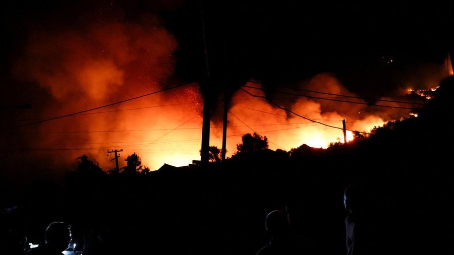 Warga setempat menyaksikan asap membubung dari kebakaran hutan yang melanda Kruja, Albania, pada 9 Agustus 2026. (REUTERS/Florion Goga)