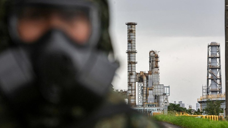 Seorang tentara yang mengenakan masker gas berjaga di dekat menara distilasi minyak saat latihan dekontaminasi bahan kimia—bagian dari latihan militer tahunan Han Kuang—di Kilang Minyak Taoyuan milik CPC Corporation di Taoyuan, Taiwan, pada 9 Agustus 2026.