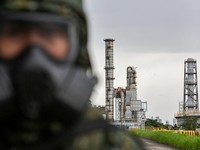 Seorang tentara yang mengenakan masker gas berjaga di dekat menara distilasi minyak saat latihan dekontaminasi bahan kimiabagian dari latihan militer tahunan Han Kuangdi Kilang Minyak Taoyuan milik CPC Corporation di Taoyuan, Taiwan, pada 9 Agustus 2