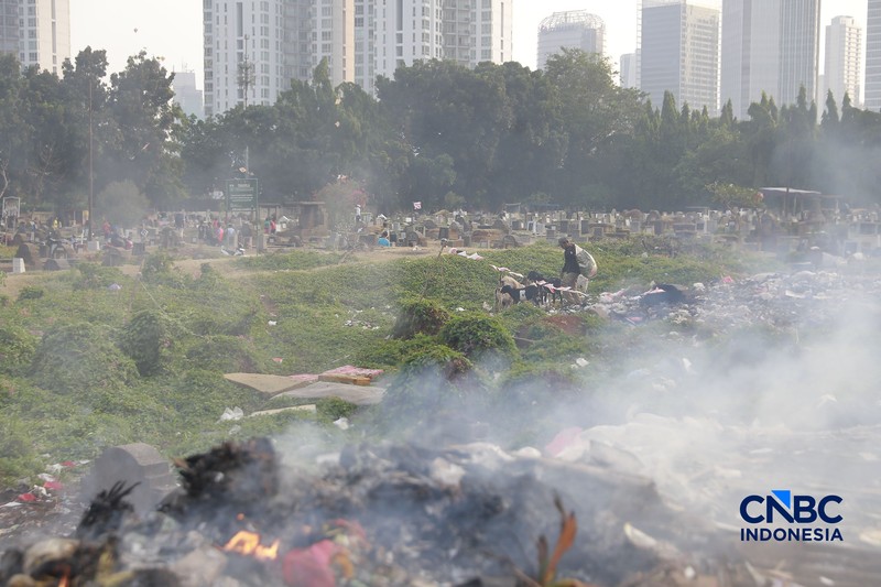 Seorang warga memilah sampah di kawasan kuburan Cina, Menteng Atas, Jakarta, Senin (10/8/2026). (CNBC Indonesia/Muhammad Sabki)