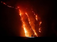 Seseorang mengamati kobaran api saat kebakaran hutan di lereng bukit di Taman Nasional Bromo Tengger Semeru di Probolinggo, Provinsi Jawa Timur, MInggu (9/8/2026). (REUTERS/Dipta Wahyu)