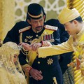 Sultan Brunei Hassanal Bolkiah memegang lengan putranya Pangeran Abdul Malik untuk memberkati istri baru Malik, Dayangku Raabi'atul 'Adawiyyah Pengiran Haji Bolkiah saat "bersanding" atau upacara penobatan di pernikahan mereka di Istana Nurul Iman di