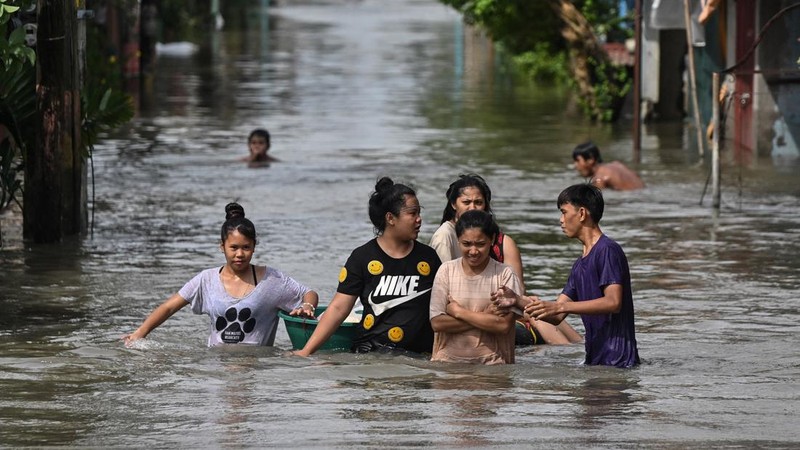Warga melintasi banjir setinggi pinggang setelah hujan lebat semalaman di Barangay Marulas, Kawit, Cavite, Filipina, 9 Agustus 2026.