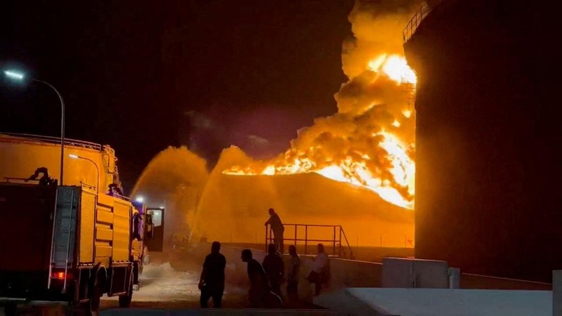 Api berkobar di dalam tangki penyimpanan sementara petugas pemadam kebakaran berupaya mengendalikan kobaran api, di sebuah kilang minyak di Zawiya, Libya, Senin (10/8/2026). (via REUTERS/VIDEO OBTAINED BY REUTERS)