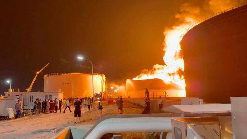 Api berkobar di dalam tangki penyimpanan sementara petugas pemadam kebakaran berupaya mengendalikan kobaran api, di sebuah kilang minyak di Zawiya, Libya, Senin (10/8/2026). (via REUTERS/VIDEO OBTAINED BY REUTERS)