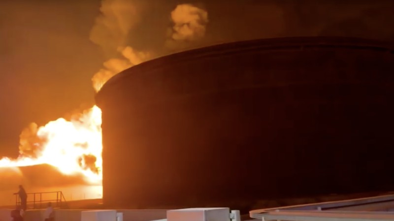 Api berkobar di dalam tangki penyimpanan sementara petugas pemadam kebakaran berupaya mengendalikan kobaran api, di sebuah kilang minyak di Zawiya, Libya, Senin (10/8/2026). (Tangkapan Layar Video/REUTERS)