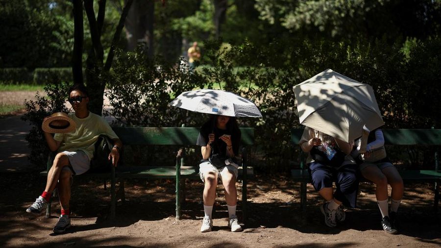 Orang-orang duduk di tempat teduh saat mengunjungi Forum Romawi di tengah suhu yang mendekati 40 derajat Celsius akibat gelombang panas, di Roma, Italia, 11 Agustus 2026.