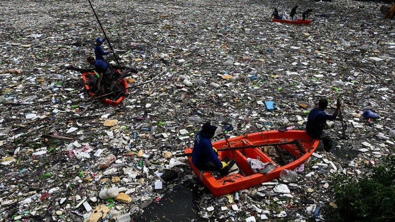 Para pekerja mengumpulkan sampah yang terbawa arus ke sungai di tengah hujan deras akibat angin muson barat daya di dekat Gereja Baclaran di Kota Paranaque, Metro Manila, Filipina, 11 Agustus 2026.