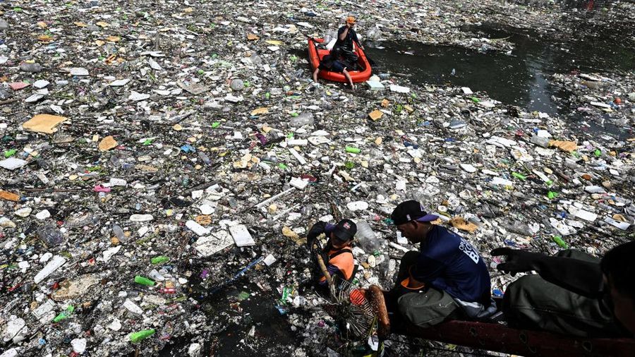 Para pekerja mengumpulkan sampah yang terbawa arus ke sungai di tengah hujan deras akibat angin muson barat daya di dekat Gereja Baclaran di Kota Paranaque, Metro Manila, Filipina, 11 Agustus 2026.