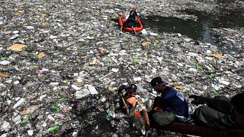 Para pekerja mengumpulkan sampah yang terbawa arus ke sungai di tengah hujan deras akibat angin muson barat daya di dekat Gereja Baclaran di Kota Paranaque, Metro Manila, Filipina, 11 Agustus 2026.
