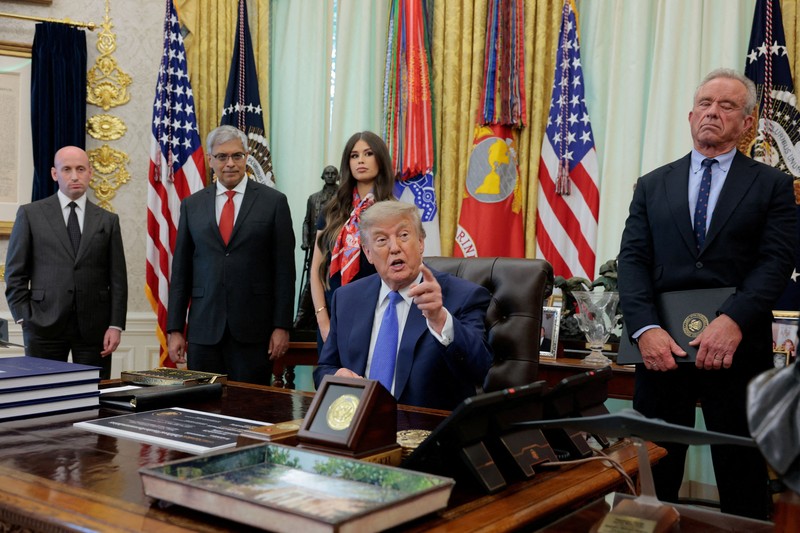 Presiden AS Donald Trump menghadiri acara penandatanganan perintah eksekutif terkait fleksibilitas vaksin, bersama Wakil Kepala Staf Gedung Putih Stephen Miller, Dr. Jay Bhattacharya, Direktur National Institutes of Health, Menteri Kesehatan dan Layanan Kemanusiaan (HHS) Robert F. Kennedy Jr., serta Jayme Leagh Franklin&mdash;pendiri dan CEO The Conservateur&mdash;di Ruang Oval Gedung Putih di Washington, D.C., AS, pada 10 Agustus 2026. (REUTERS/Kylie Cooper)