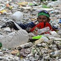 Seorang pekerja mengumpulkan sampah yang terbawa arus ke sungai di tengah hujan deras akibat angin muson barat daya, di dekat Gereja Baclaran di Kota Paranaque, Metro Manila, Filipina, 11 Agustus 2026. (REUTERS/NOEL CELIS)