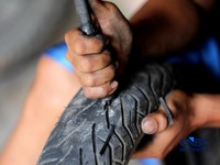 Seorang pekerja menyelesaikan pengerikan ulang ban motor bekas (Vulkanisir) di Kawasan Beji, Depok, Jawa Barat, Selasa (11/8/2026). (CNBC Indonesia/Tri Susilo)