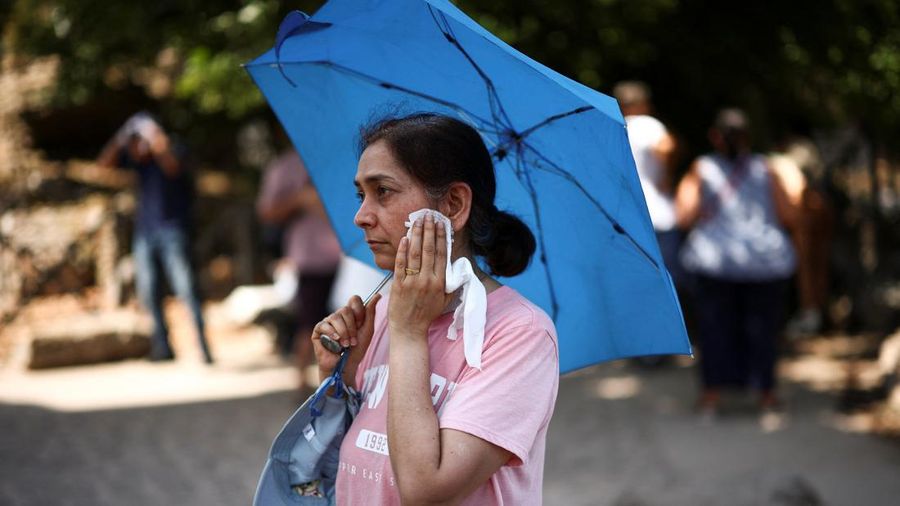 Seorang wanita menyeka keringat dari wajahnya saat mengunjungi Forum Romawi di tengah suhu yang mendekati 40 derajat Celsius akibat gelombang panas, di Roma, Italia, 11 Agustus 2026.