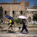 Warga menggunakan payung untuk berlindung dari terik matahari saat mengunjungi Forum Romawi di tengah suhu yang mendekati 40 derajat Celsius akibat gelombang panas, di Roma, Italia, 11 Agustus 2026. (REUTERS/Guglielmo Mangiapane)