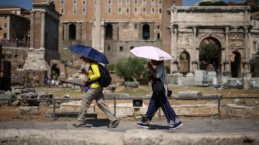 Warga menggunakan payung untuk berlindung dari terik matahari saat mengunjungi Forum Romawi di tengah suhu yang mendekati 40 derajat Celsius akibat gelombang panas, di Roma, Italia, 11 Agustus 2026.