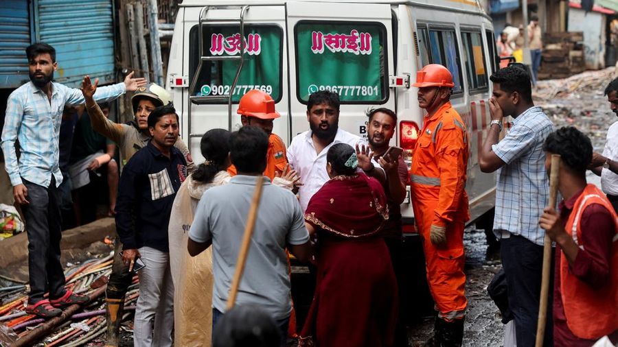 Anggota keluarga dari seorang korban meninggal menunggu untuk masuk ke dalam ambulans setelah terjadi tanah longsor, menyusul runtuhnya sebagian bukit yang menimpa rumah-rumah di kawasan permukiman padat penduduk di Mumbai, India, pada 12 Agustus 2026.