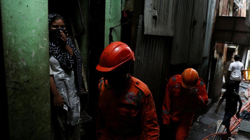 Petugas Pasukan Tanggap Bencana Nasional (NDRF) berjalan menuju lokasi tanah longsor setelah sebagian bukit runtuh menimpa rumah-rumah di kawasan permukiman kumuh di Mumbai, India, pada 12 Agustus 2026.