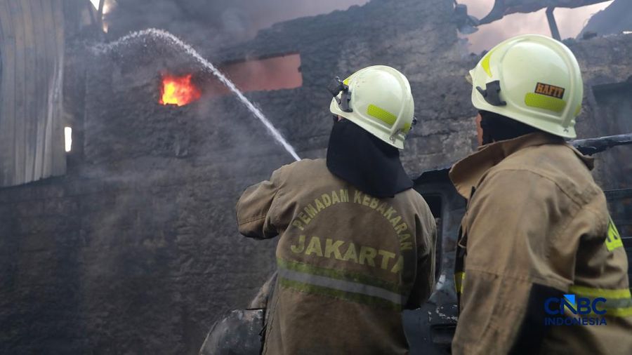 Sejumlah petugas pemadam kebakaran berusaha memadamkan api di sebuah pabrik bingkai yang terbakar, di Jalan Lampiri, Jakarta Timur, Rabu (12/08/2026). (CNBC Indonesia/Muhammad Sabki)