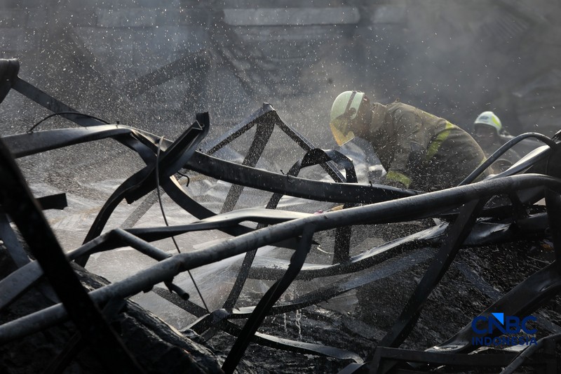 Sejumlah petugas pemadam kebakaran berusaha memadamkan api di sebuah pabrik bingkai yang terbakar, di Jalan Lampiri, Jakarta Timur, Rabu (12/08/2026). (CNBC Indonesia/Muhammad Sabki)