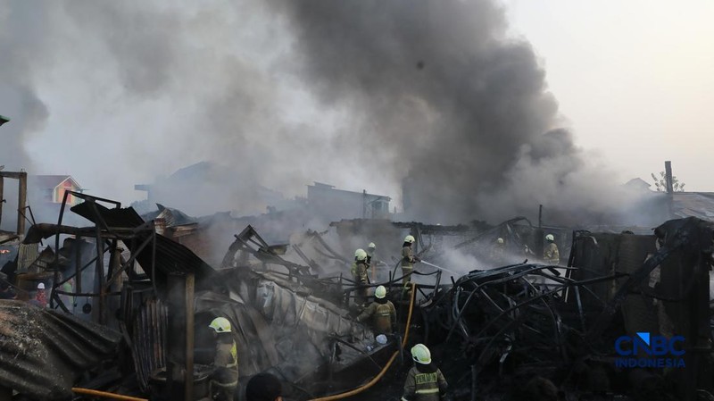 Sejumlah petugas pemadam kebakaran berusaha memadamkan api di sebuah pabrik bingkai yang terbakar, di Jalan Lampiri, Jakarta Timur, Rabu (12/08/2026). (CNBC Indonesia/Muhammad Sabki)