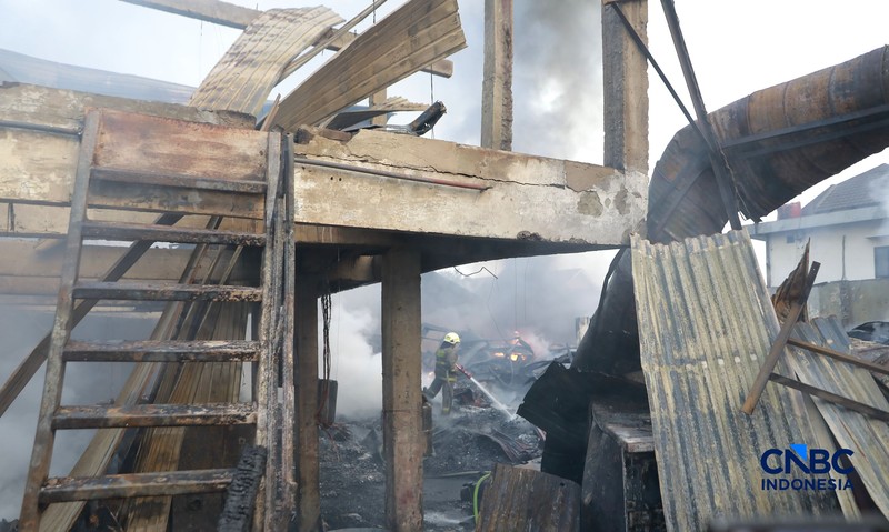 Sejumlah petugas pemadam kebakaran berusaha memadamkan api di sebuah pabrik bingkai yang terbakar, di Jalan Lampiri, Jakarta Timur, Rabu (12/08/2026). (CNBC Indonesia/Muhammad Sabki)