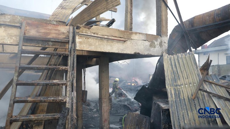 Sejumlah petugas pemadam kebakaran berusaha memadamkan api di sebuah pabrik bingkai yang terbakar, di Jalan Lampiri, Jakarta Timur, Rabu (12/08/2026). (CNBC Indonesia/Muhammad Sabki)