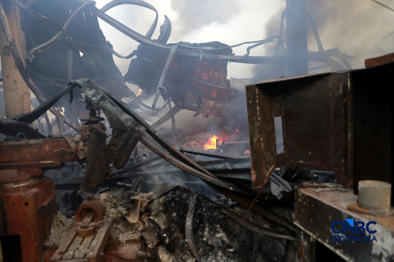 Sejumlah petugas pemadam kebakaran berusaha memadamkan api di sebuah pabrik bingkai yang terbakar, di Jalan Lampiri, Jakarta Timur, Rabu (12/08/2026). (CNBC Indonesia/Muhammad Sabki)