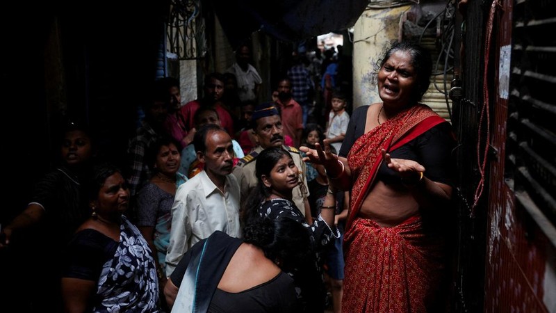 Seorang wanita meratapi kematian putranya akibat tanah longsor setelah sebagian bukit runtuh menimpa rumah-rumah di kawasan permukiman kumuh di Mumbai, India, pada 12 Agustus 2026.