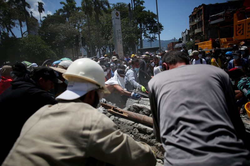 Warga sedang membersihkan puing-puing pascagempa bumi di Pereira, Kolombia, Selasa (11/8/2026). (REUTERS/Luisa Gonzalez)