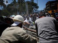 Warga sedang membersihkan puing-puing pascagempa bumi di Pereira, Kolombia, Selasa (11/8/2026). (REUTERS/Juan David Duque)