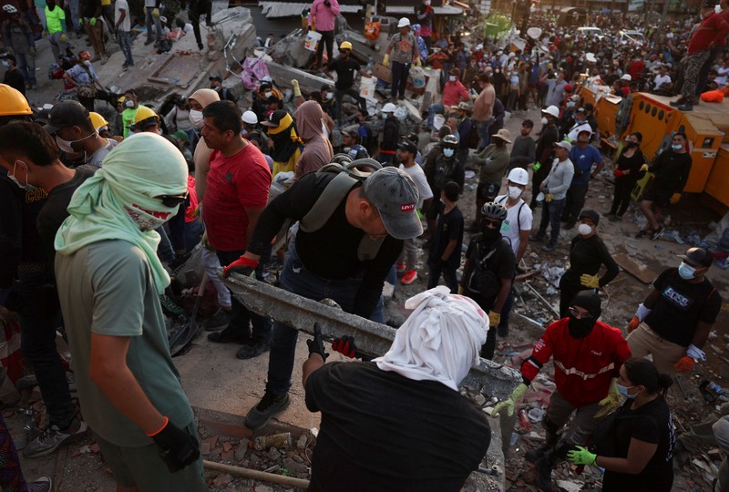 Warga sedang membersihkan puing-puing pascagempa bumi di Pereira, Kolombia, Selasa (11/8/2026). (REUTERS/Luisa Gonzalez)