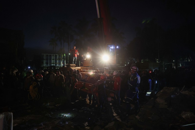 Warga sedang membersihkan puing-puing pascagempa bumi di Pereira, Kolombia, Selasa (11/8/2026). (REUTERS/Luisa Gonzalez)